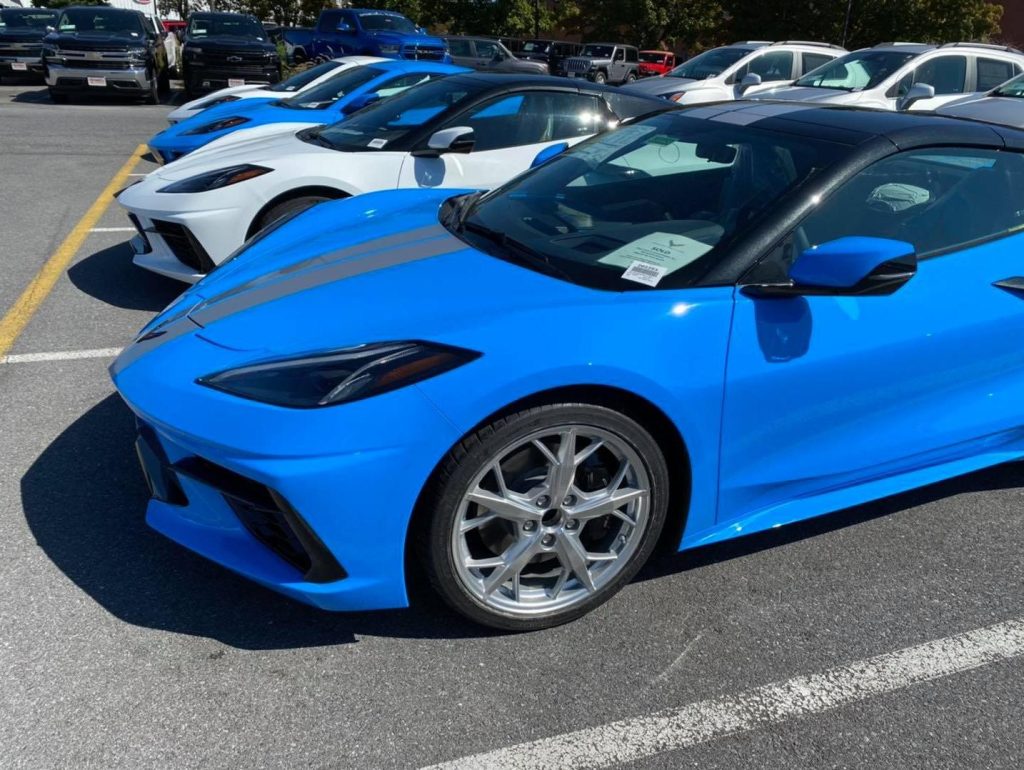 Bright blue Chevrolet Corvette parked in a dealership lot in Gaithersburg, Maryland, with other Corvette models lined up in the background, highlighting customization options and color variety.