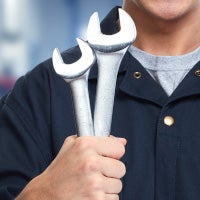mechanic holding wrenches
